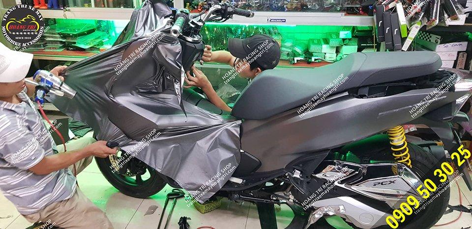 Nhân viên đang thi công dán decal nhôm xước PCX 2018